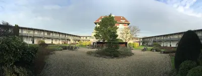 a courtyard with a tree in front of a building at die Perle in Zandvoort