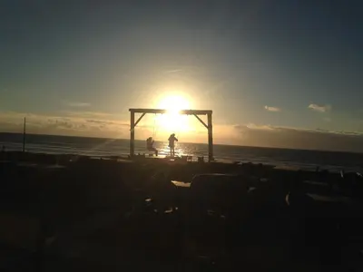 a person standing on the beach at the sunset at die Perle in Zandvoort