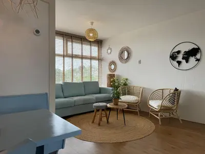 a living room with a blue couch and chairs at die Perle in Zandvoort