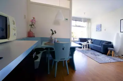 a kitchen with a table and chairs and a couch at die Perle in Zandvoort