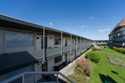 a long building with a balcony and a yard at die Perle in Zandvoort