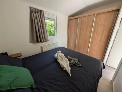 a bedroom with a bed with a towel on it at Holiday House 4 guests at Spaarnwoude in Velsen-Zuid