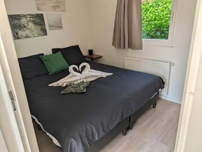 a bedroom with a bed with a ribbon on it at Holiday House 4 guests at Spaarnwoude in Velsen-Zuid