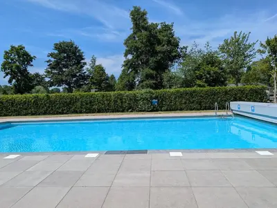 a swimming pool with blue water in a yard at Holiday House 4 guests at Spaarnwoude in Velsen-Zuid