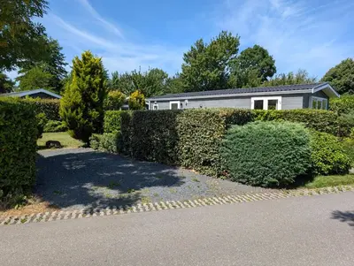 a house with a hedge in front of a house at Holiday House 4 guests at Spaarnwoude in Velsen-Zuid