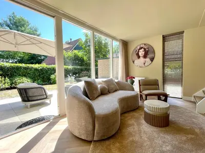 a living room with a couch and a large window at Zon in de Duinen by Droomvilla in Sint Maarten