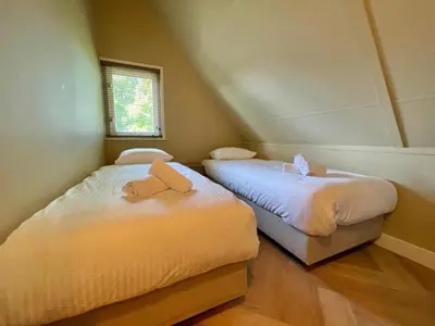 two beds in a room with two towels on them at Zon in de Duinen by Droomvilla in Sint Maarten