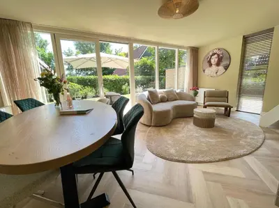 a living room with a table and a couch at Zon in de Duinen by Droomvilla in Sint Maarten