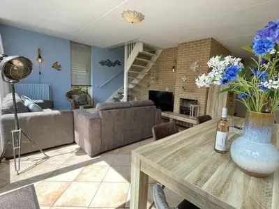 a living room with a vase of flowers on a table at Zon op de Wielen by Droomvilla in Sint Maarten