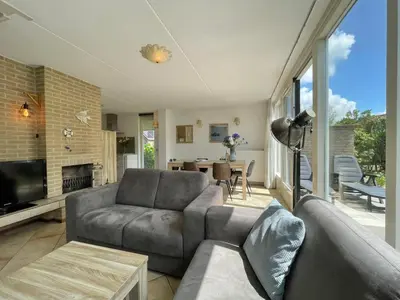 a living room with a couch and a television at Zon op de Wielen by Droomvilla in Sint Maarten