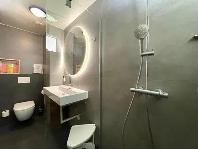 a bathroom with a shower and a toilet and a sink at Zon op de Wielen by Droomvilla in Sint Maarten