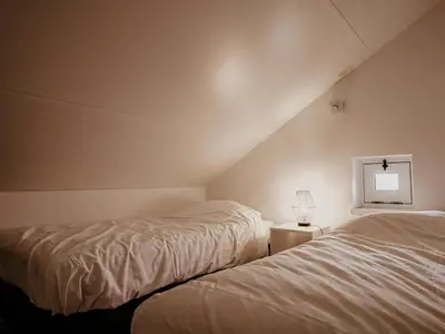 a bedroom with two beds and a lamp on a table at Nova Meer in Uitgeest