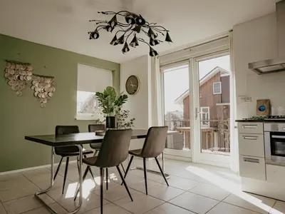 a kitchen and dining room with a table and chairs at Nova Meer in Uitgeest