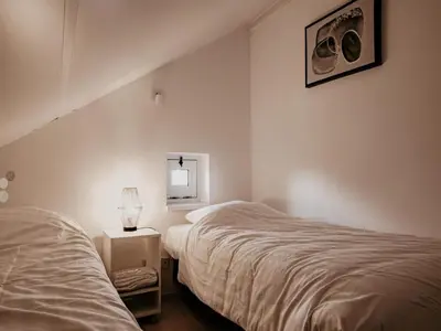 a bedroom with two beds and a mirror at Nova Meer in Uitgeest