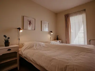 a bedroom with a white bed and a window at Waterbase in Uitgeest