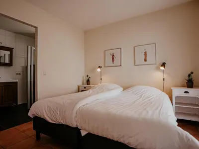 a bedroom with a large bed with white sheets at Waterbase in Uitgeest