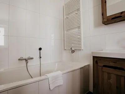 a white bathroom with a tub and a sink at Waterbase in Uitgeest