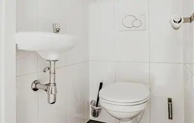 a white bathroom with a toilet and a sink at Oostergeest Beneden 2 Slaapk in Uitgeest