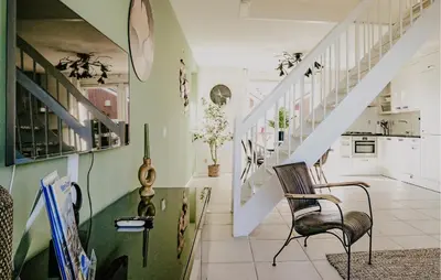 a living room with a staircase and a chair at Oostergeest Beneden 2 Slaapk in Uitgeest