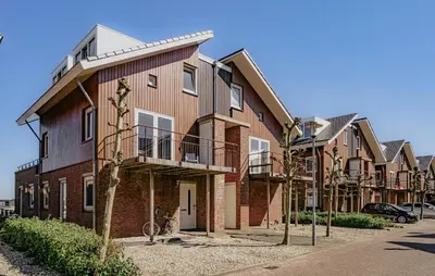 a large brick building with balconies on a street at Oostergeest Beneden 2 Slaapk in Uitgeest