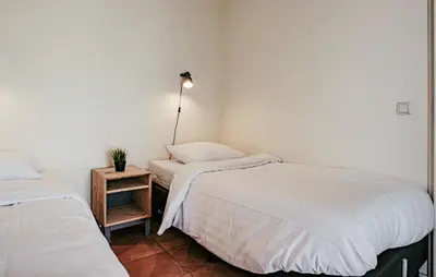 a bedroom with two beds and a lamp on a table at Westergeest Beneden 2 Slaapk in Uitgeest