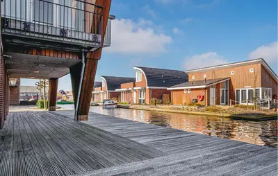 a wooden dock with houses and a river at Westergeest Beneden 2 Slaapk in Uitgeest