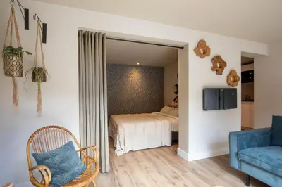 a bedroom with a bed and a couch and a mirror at Beachbreak Boulevard in Katwijk aan Zee