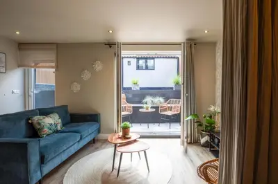 a living room with a blue couch and a table at Beachbreak Boulevard in Katwijk aan Zee