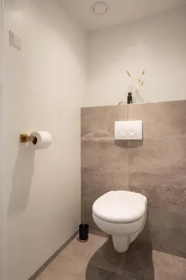 a bathroom with a white toilet in a room at Beachbreak Boulevard in Katwijk aan Zee