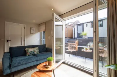 a living room with a couch and a sliding glass door at Beachbreak Boulevard in Katwijk aan Zee