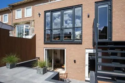 a brick house with a large window on it at Beachbreak Boulevard in Katwijk aan Zee