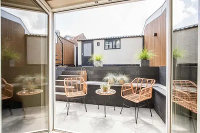 a patio with chairs and a table on a balcony at Beachbreak Boulevard in Katwijk aan Zee