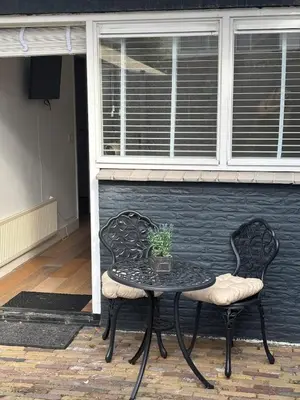 a black table and two chairs with a plant on it at Casa Luz & Luna in Akersloot