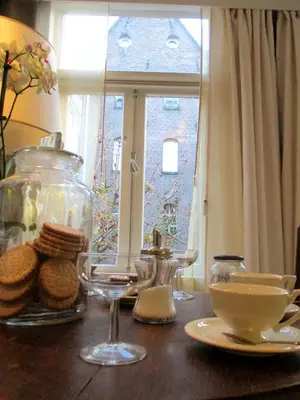 a table with cookies and glasses and a window at Miss Jordaan for Quiet Travellers in Amsterdam