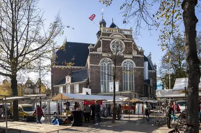 a large building with a clock tower in a market at Miss Jordaan for Quiet Travellers in Amsterdam