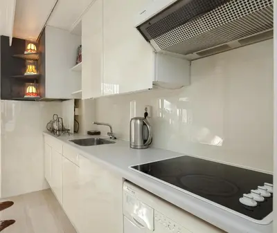 a kitchen with white cabinets and a black counter top at Miss Jordaan for Quiet Travellers in Amsterdam