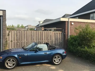 a blue car parked in front of a fence at Fewo Klimduin Castricum in Castricum