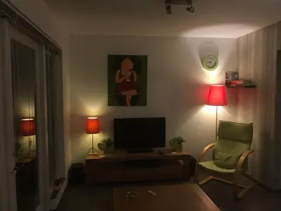 a living room with a television and a chair at Fewo Klimduin Castricum in Castricum