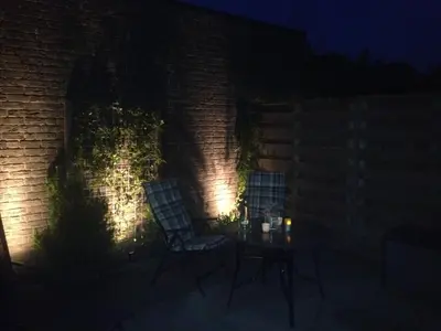 a patio with two chairs and a table at night at Fewo Klimduin Castricum in Castricum