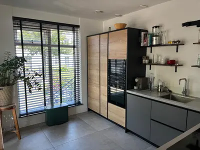 a kitchen with a sink and a large window at Wellness Villa Binnenhof in Noordwijk