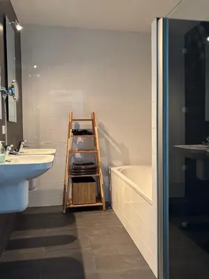 a bathroom with a ladder next to a sink and a tub at Wellness Villa Binnenhof in Noordwijk