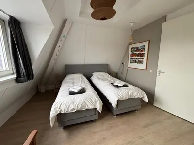 a bedroom with two beds in a attic at Wellness Villa Binnenhof in Noordwijk