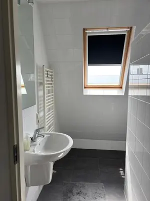 a white bathroom with a sink and a window at Wellness Villa Binnenhof in Noordwijk
