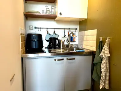 a small kitchen with a sink and a stove at Cosy Studio, with outdoor swimming in Amsterdam