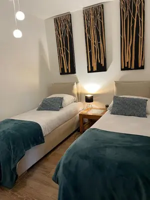 two beds in a room with paintings on the wall at Garden Apartment, Amsterdam in Amsterdam