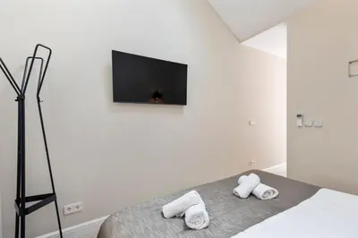 a white bedroom with a bed with two towels at Nofa 7 - Zandvoort in Zandvoort