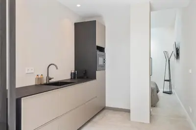 a kitchen with white cabinets and a sink at Nofa 7 - Zandvoort in Zandvoort
