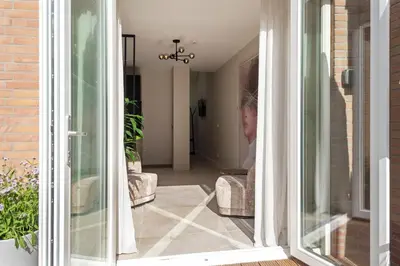 a person sitting in a chair looking out of a glass door at Nofa 7 - Zandvoort in Zandvoort