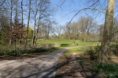 a dirt road in a park with people walking down it at Light and quiet haven next to park in Amsterdam