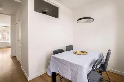 a white dining room with a table and chairs at Light and quiet haven next to park in Amsterdam